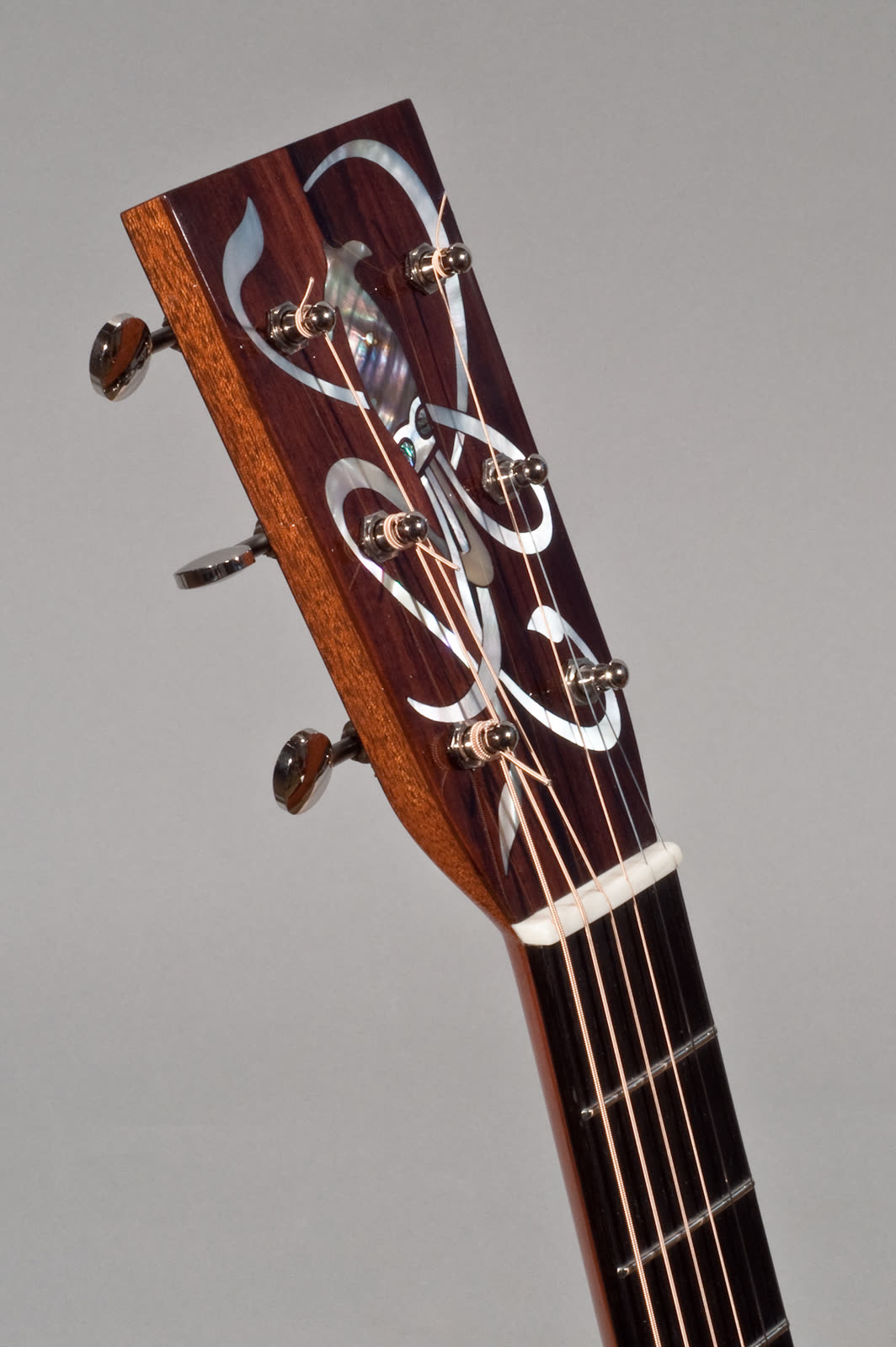 Orchestra Model guitar — headstock, pearl and abalone inlay, angled view